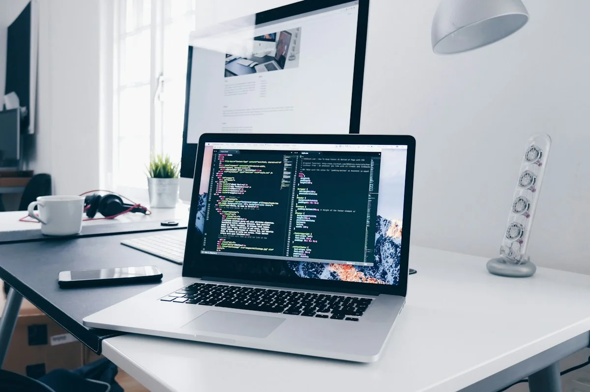 Laptop displaying code on a bright work desk